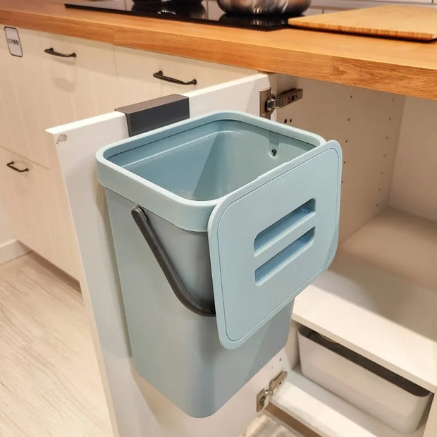 Blue trash bin mounted inside a kitchen cabinet.