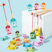 Colorful wooden fish-shaped letters hanging from strings on a light blue background