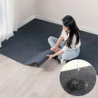 Person unrolling a carpet roll on a wooden floor with an inset showing water droplets on the carpet.