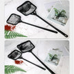 Two black butterfly nets on a marble surface with greenery and a magazine.