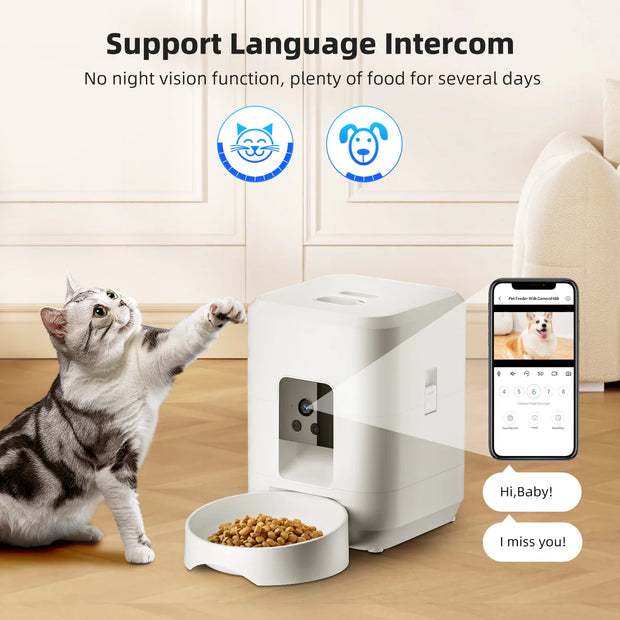 Cat interacting with a pet feeder and bowl on a wooden floor, with smartphone app interface displayed.