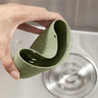 Green silicone cup held over a sink