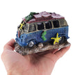 Hand holding a decorative bus figurine on a white background