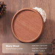 Round fluted coaster made of ebony wood on a wooden surface with text detailing its dimensions.