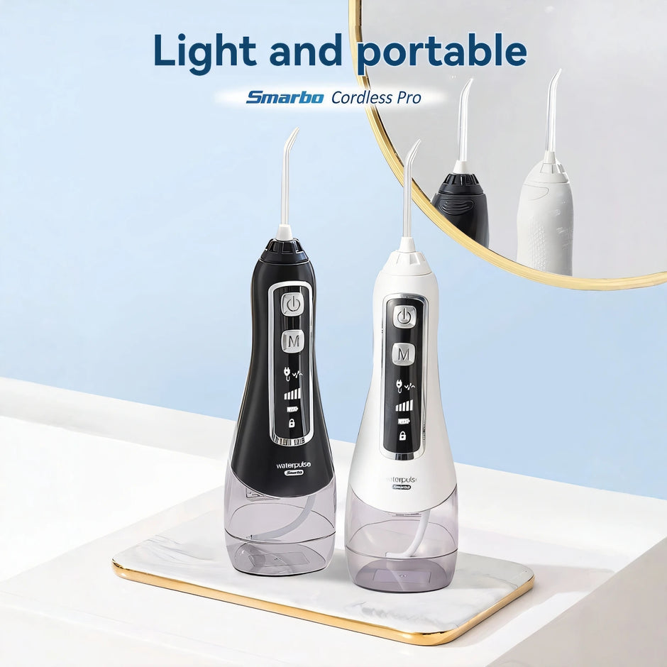 Two dental water flossers, one black and one white, on a light surface with a mirror in the background.