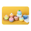 Colorful bath bombs with small figurines on a yellow background