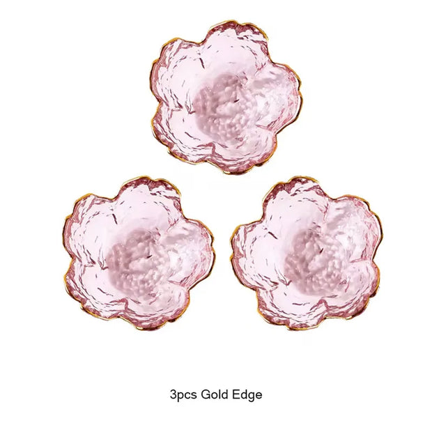 Three pink flower-shaped dishes with gold edges on a white background