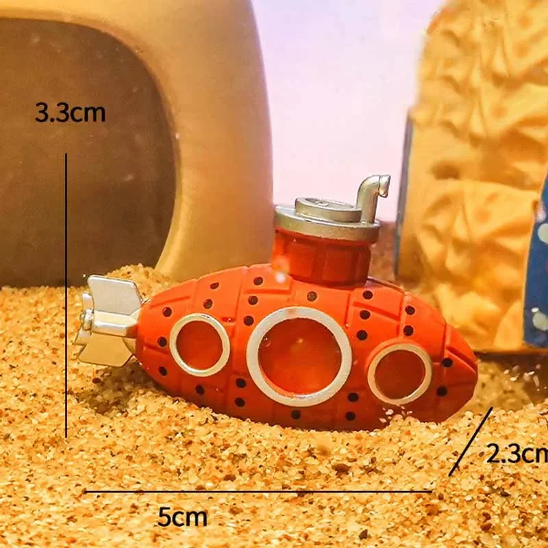 Small red submarine toy with measurements on a sandy surface