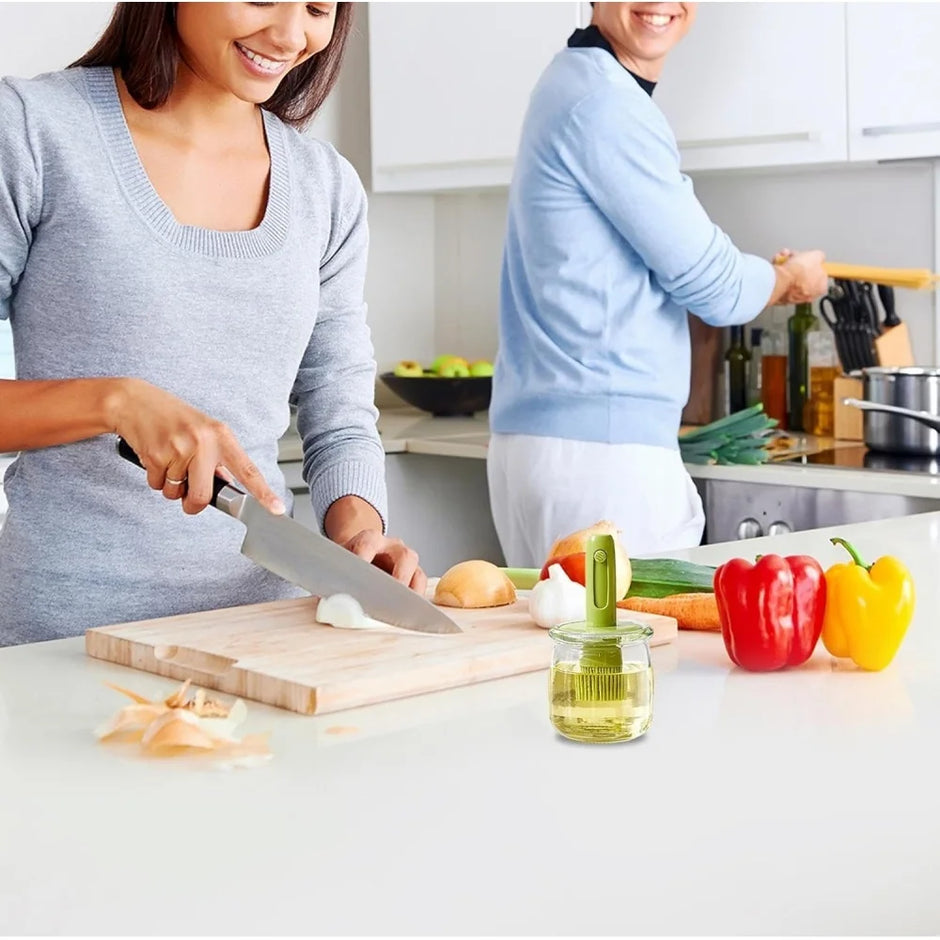Two people cooking together in a kitchen with vegetables and oil on the counter.