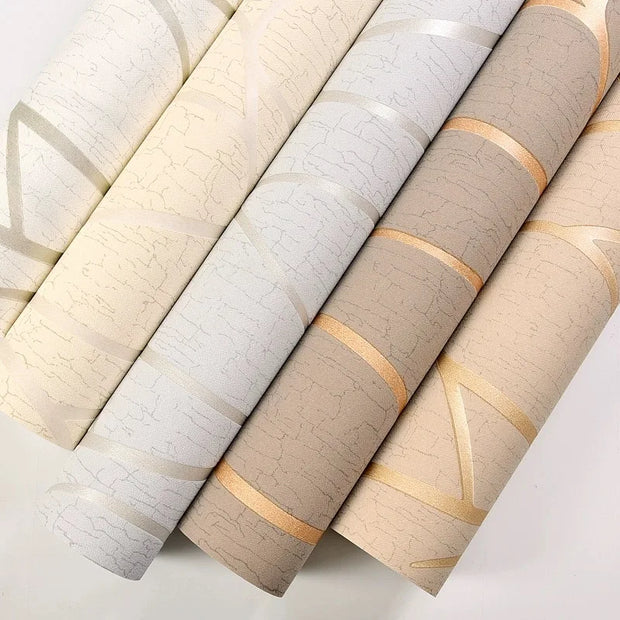 Rolls of textured wallpaper with gold accents on a light gray background