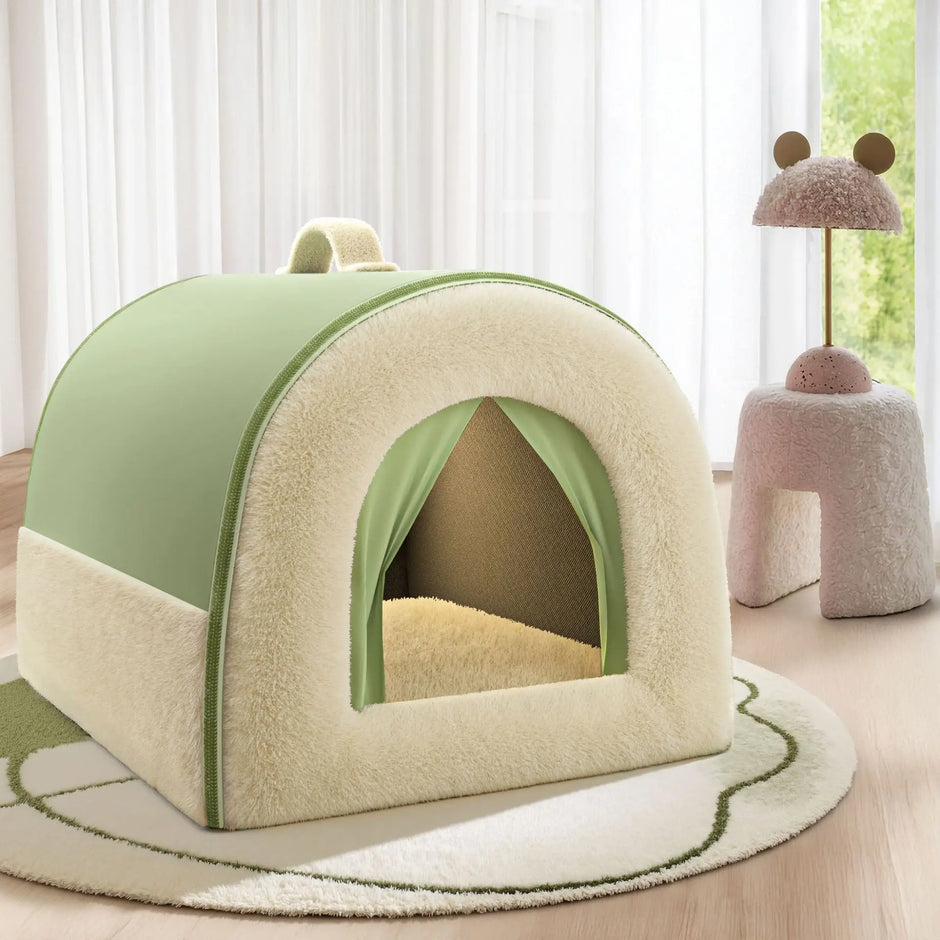 Green and beige pet house on a wooden floor with a soft rug and a pink cushioned stool in the background.