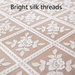 Close-up of white floral lace on beige fabric with 'Bright silk threads' text.