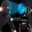 Person wearing a balaclava with a security camera and smartphone displaying monitoring app.