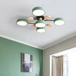 Modern ceiling light fixture in a room with green walls and a window.