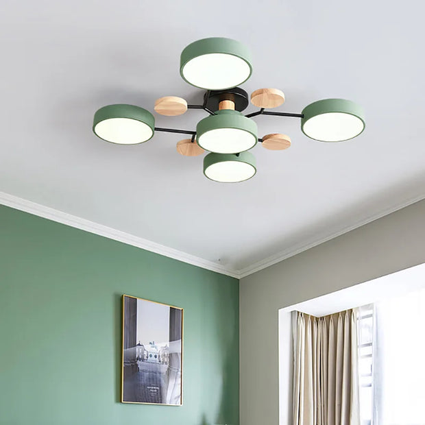 Modern ceiling light fixture in a room with green walls and a window.