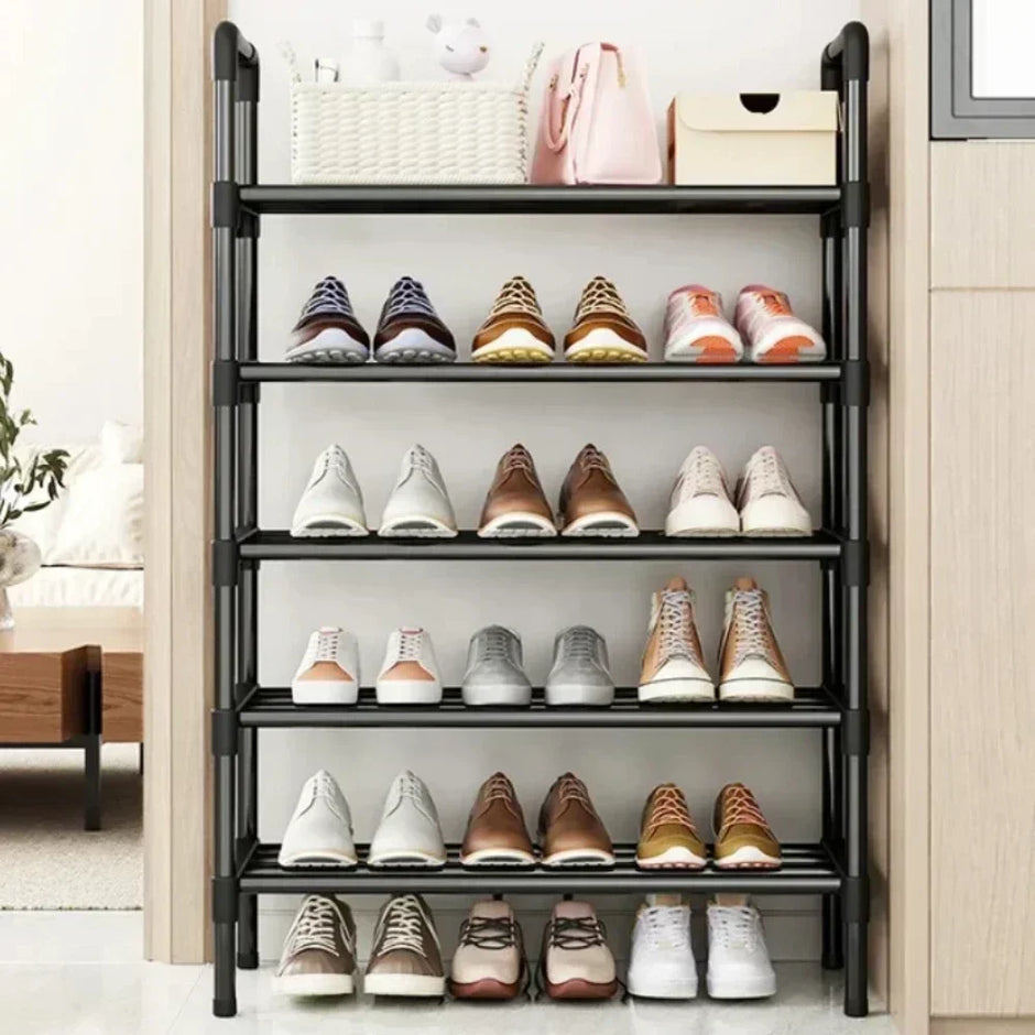 Black shoe rack with various shoes on shelves in a room setting.