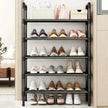 Black shoe rack with various shoes on shelves in a room setting.