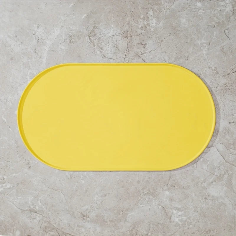 Yellow bath mat on a gray tiled floor