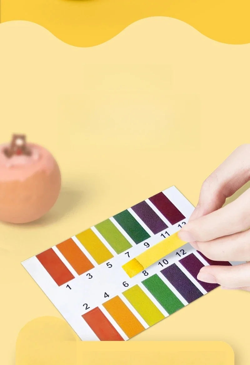 pH test strip with a hand holding it on a yellow background