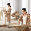 Woman ironing clothes in a bright room with minimal decor