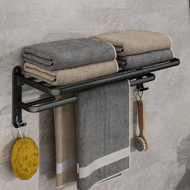 Towel rack with folded towels and cleaning tools against a gray tiled wall.