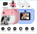 Two children's digital cameras, a 32GB memory card, card reader, and cleaning wipes on a colorful background with 'Choice' branding.