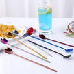 Colorful spoons on a table with a glass of blue lemonade.