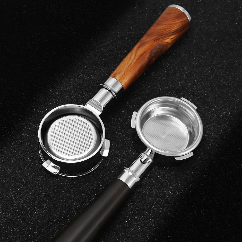 Two metal coffee filters with wooden and black handles on a dark surface