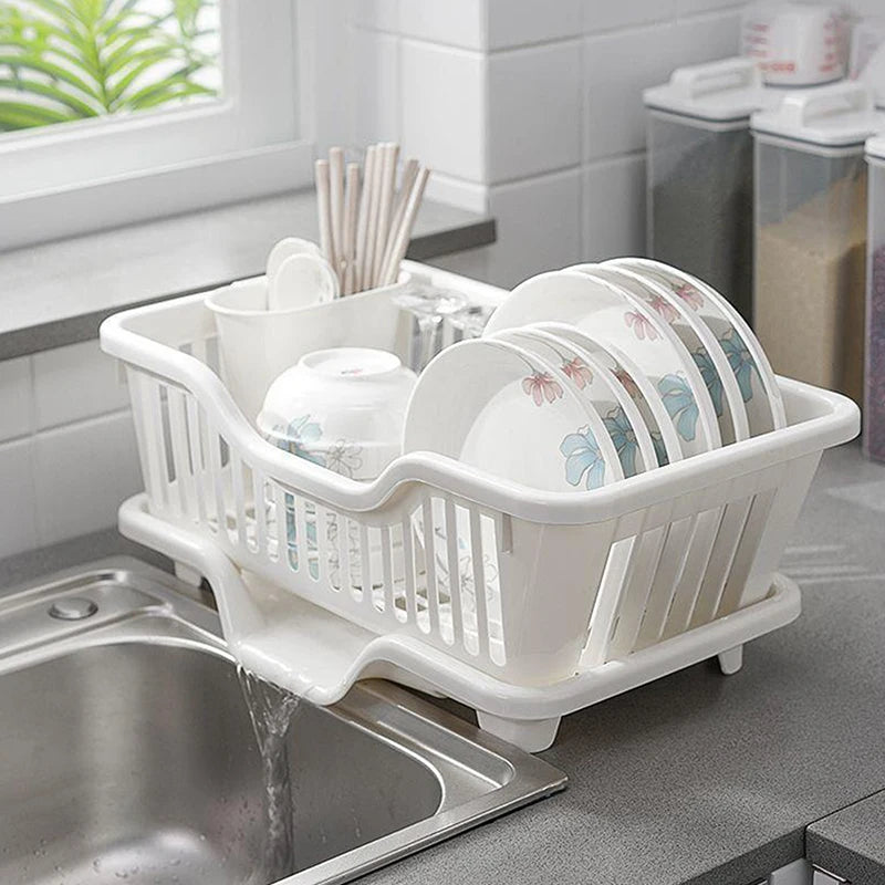 White dish rack with dishes on a kitchen counter next to a sink