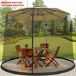 Beige patio umbrella with mosquito net over a wooden outdoor table and chairs on a grassy area.