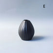 Black textured vase on a light gray background