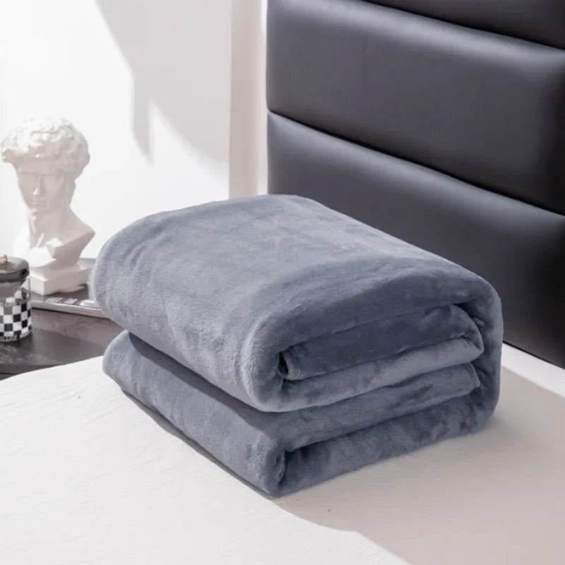Folded gray blanket on a surface with a blurred background