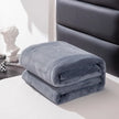Folded gray blanket on a surface with a blurred background