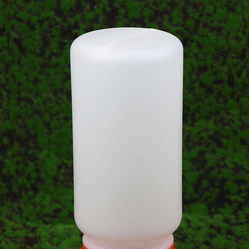 White cylindrical bottle with a red cap on a green textured background