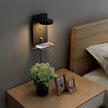 Wall-mounted lamp on a nightstand with a vase of flowers and photo frames in a bedroom setting.