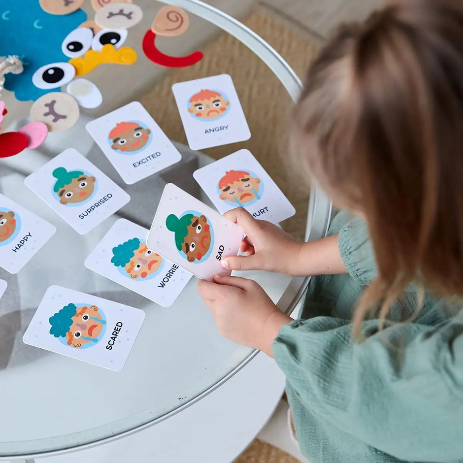 Child playing with emotion cards on a round table
