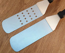Two sanding blocks with different grits on a wooden surface