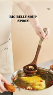 Person holding a large wooden spoon over a pot of soup with text 'BIG BELLY SOUP SPOON'.
