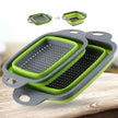 Collapsible green and gray colander on a wooden surface