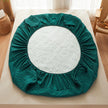 Green circular mattress cover on a bed with a white floral patterned interior.
