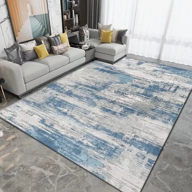 Living room with a gray sectional sofa and a blue and gray patterned rug.