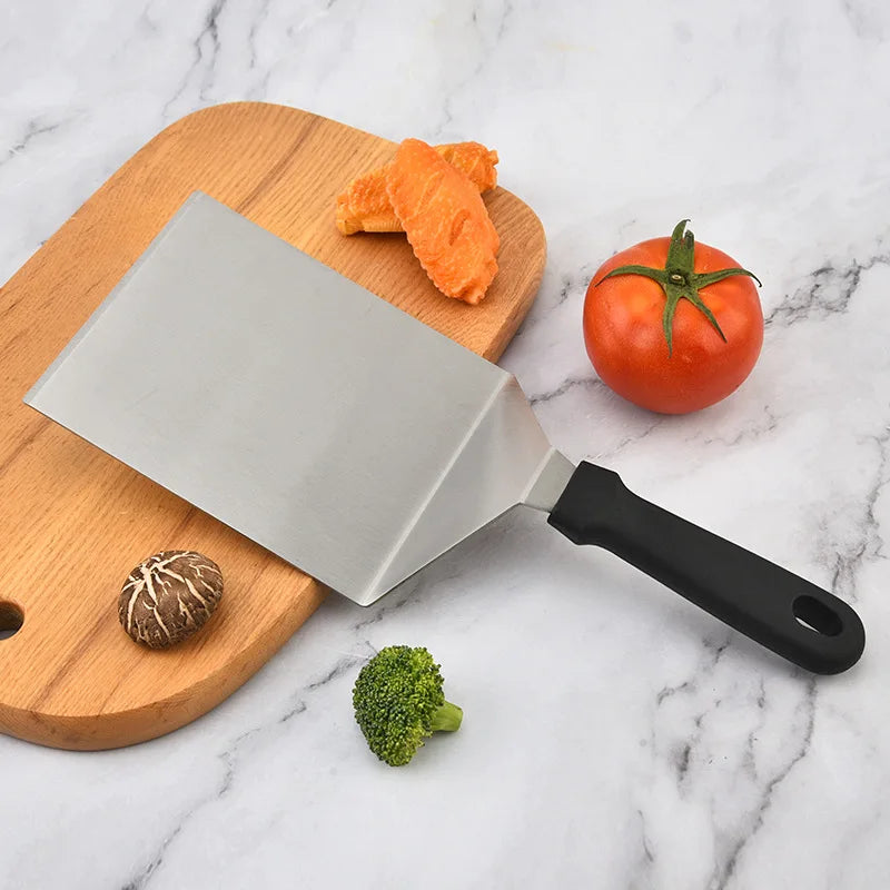 Knife on a wooden cutting board with vegetables on a marble surface