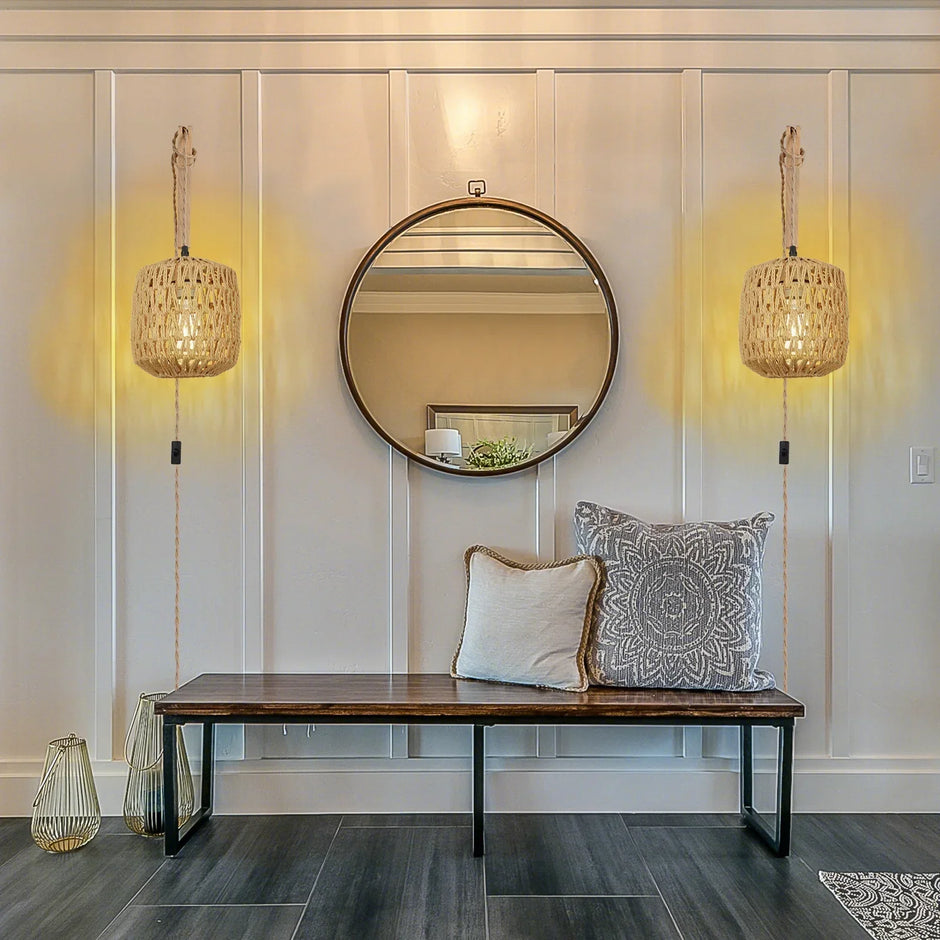 Modern interior with a round mirror, wooden bench, and decorative pillows.