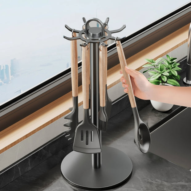 Kitchen utensil holder with 360-degree rotation feature, held by a hand in a kitchen setting.