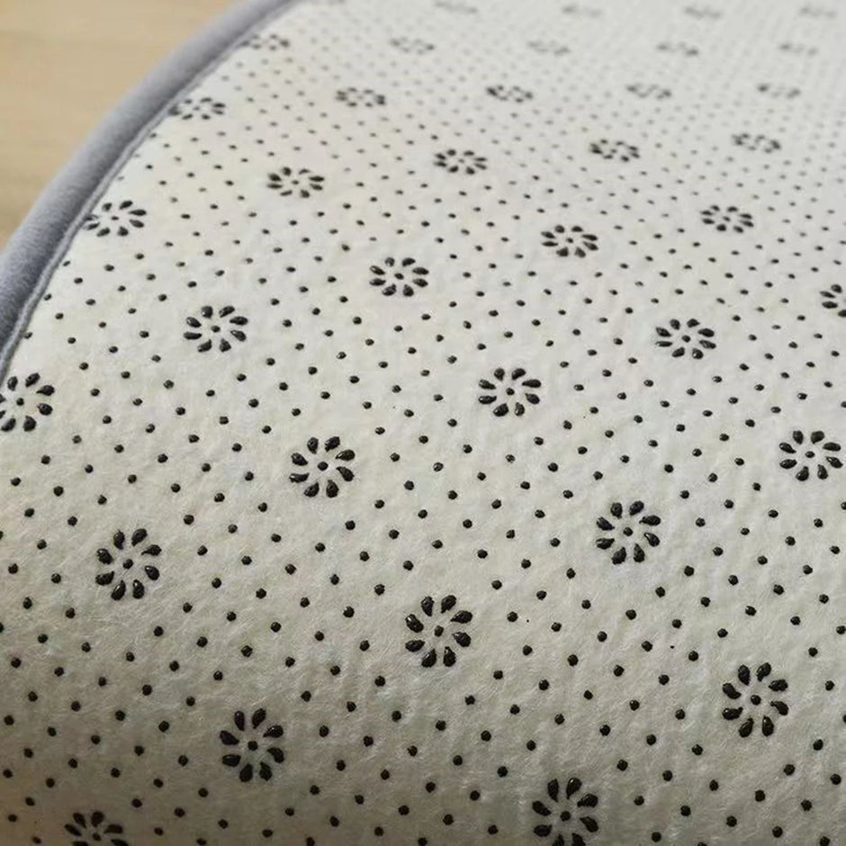 Close-up of a textured surface with black floral patterns on a beige background
