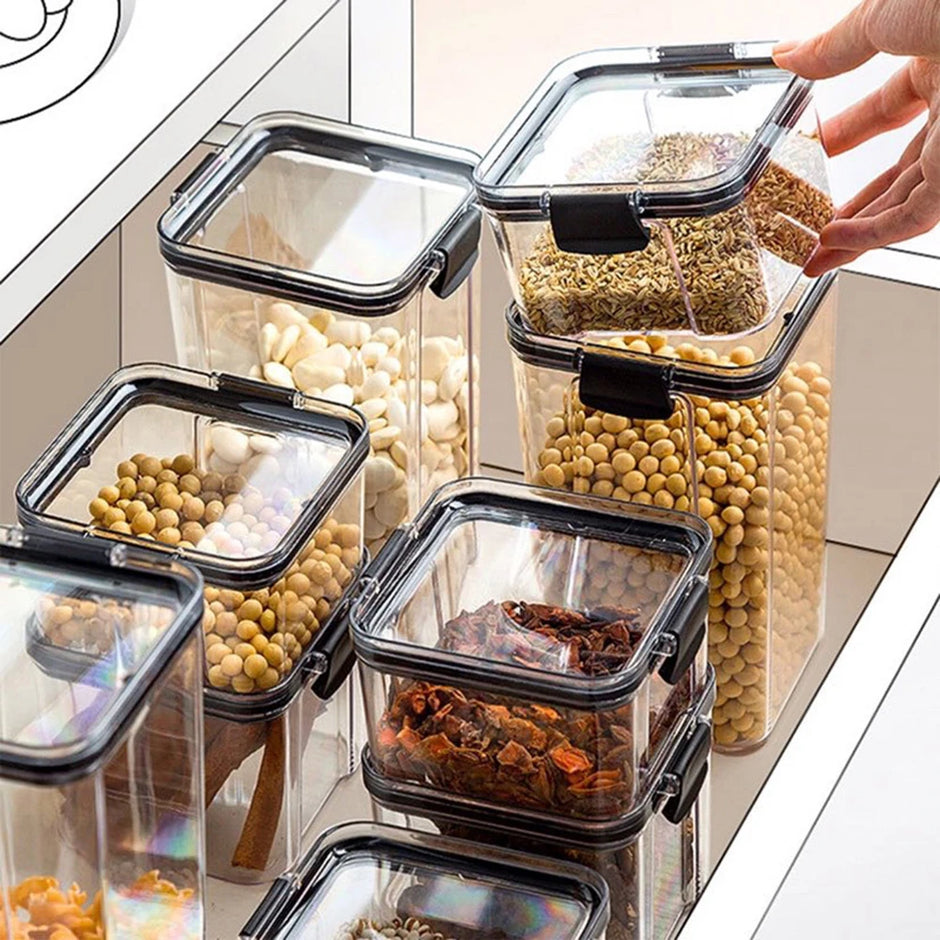 Set of clear food storage containers with black lids on a kitchen counter.