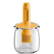 Clear glass container with a yellow brush and handle on a white background