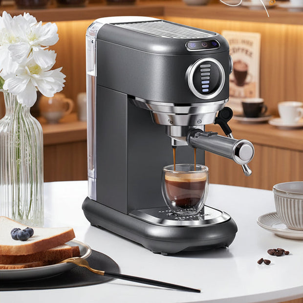 Espresso machine making a cup of coffee on a white surface with flowers and a glass of water in the background.