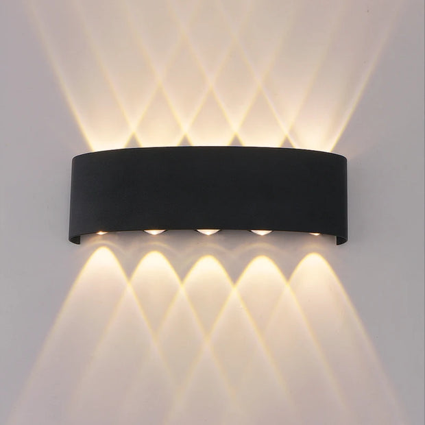 Black wall-mounted outdoor light fixture on a gray wall