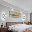 Modern bedroom with a bed, nightstands, wall art, and decorative items.
